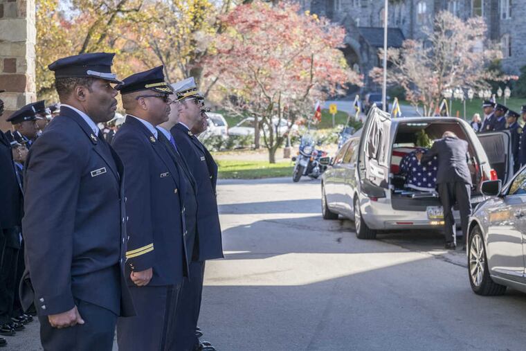 An honor guard made up of fire and police ranks outside the New Covenant Church in Germantown as Harold B. Hairston's casket is placed in the hearse.