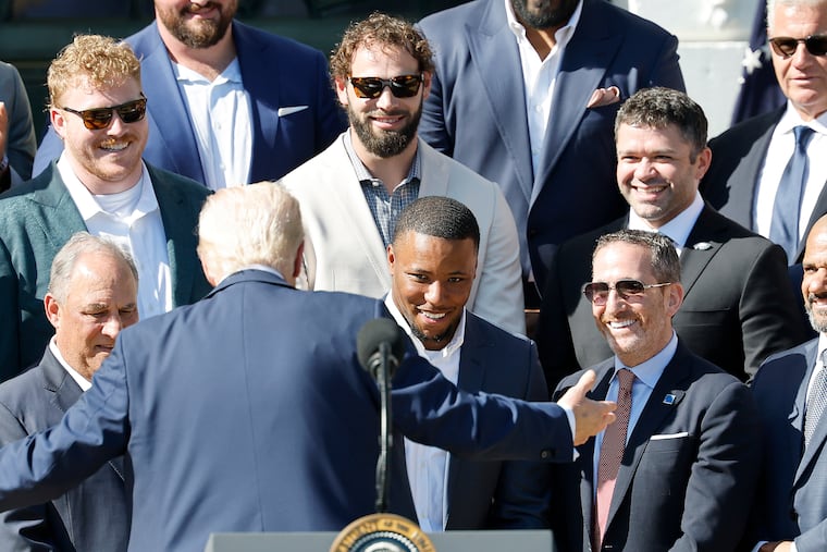 Eagles running back Saquon Barkley (center) and general manager Howie Roseman (right) look toward President Donald Trump during the White House visit.