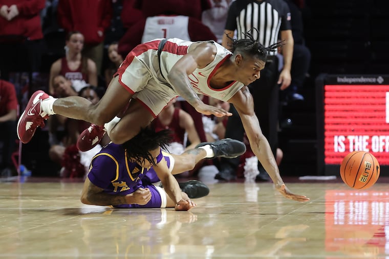 Jahlil White (top) of Temple is upended as goes after a loose ball against Jaden Walker of East Carolina during the 2nd half at the Liacouras Center on Jan. 18, 2023.