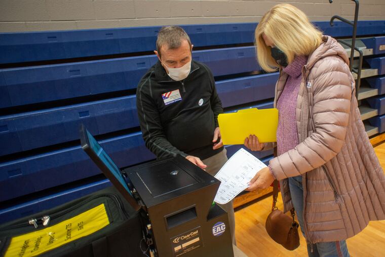 A Buckingham resident scanned her ballot as poll worker Will Faussett assisted at Central Bucks East High School last November.
