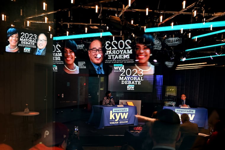 Monitors are reflected in glass windows of the KYW Newsradio studios as Democrat Cherelle Parker and Republican David Oh meet in their only debate before tomorrow's mayoral election.