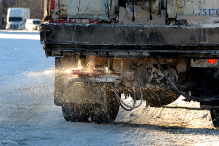 A dump truck spreading salt along American Street at Lehigh Avenue on Tuesday. (Tom Gralish / Staff Photographer)