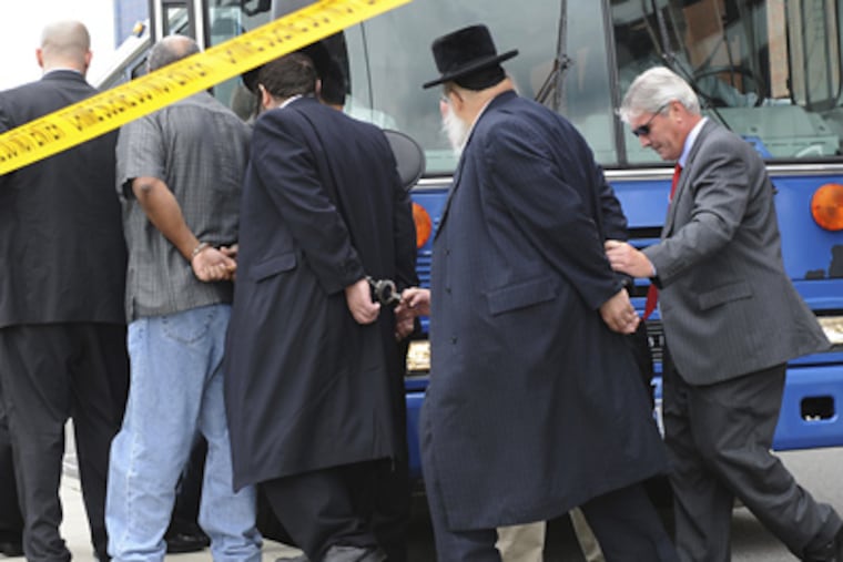 FBI agents escort some of the 44 people arrested yesterday from the agency’s office in Newark, N.J. Among those charged were a number of rabbis. (Louis Lanzano / Associated Press)
