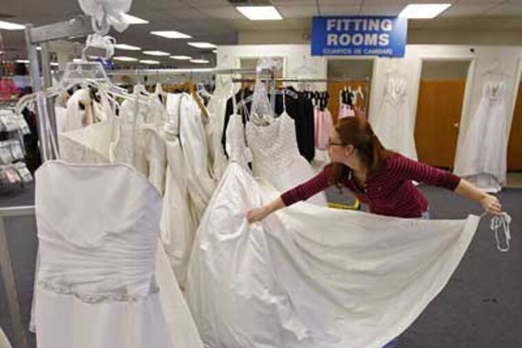 Mary Palmisano readies gowns for the big sale this Saturday at The Goodwill Store in Pennsauken. She says there will be about 100 dresses. Many are new, donated by bridal shops. (Michael S. Wirtz / Staff Photographer)