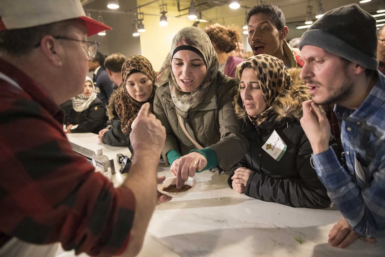 Syrian refugee Abeer Bdaiwi samples chipotle that chef Jack McDavid (left) used.