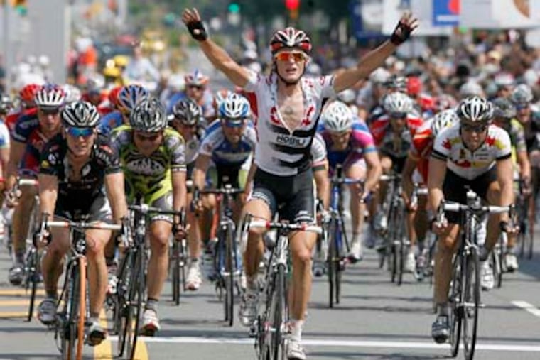 Bicyclists cross the finish line last year. Race organizers face a $500,000 budget hole for this year's race. (Charles Fox / Staff Photographer)