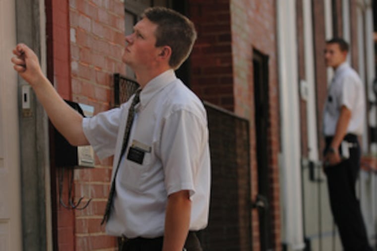 Rodney Mills (foreground) knocks on a door while his partner, Robert Keach, waits for a response. "It's been a life-changing experience," said Mills, who hails from Salt Lake City.