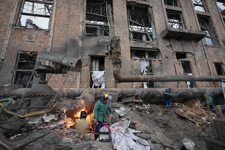Workers clean up damage at Darnytsia Thermal Power Plant after a Russian attack in Kyiv, Ukraine, on Wednesday.