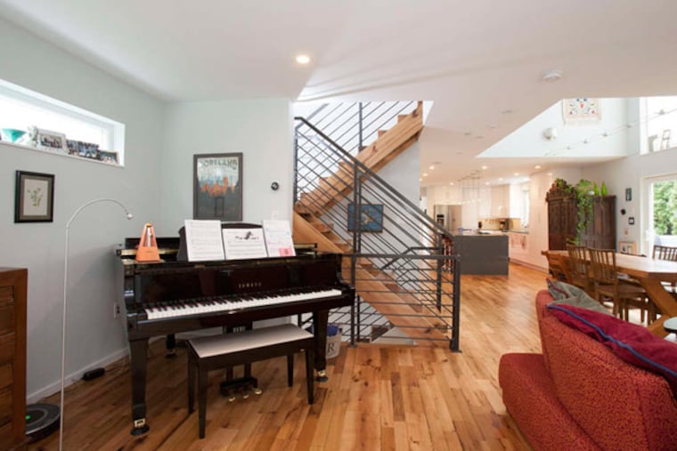 The view from the Rosses' living room shows the expansive staircase to the second floor, the dining area, and the kitchen. The area features a French oak table next to the window.