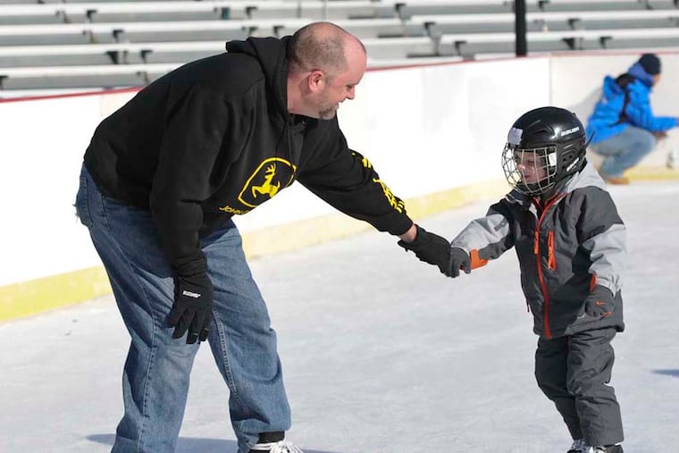 Jackson Davis, 4, gets a helping hand from his father, Bryan, at the Winterfest Ice Skating Rink at Cooper River Park in Pennsauken on November 28, 2014. ( RON TARVER / Staff Photographer )
