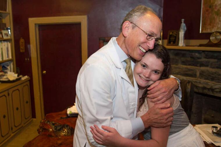 Sherman Leis, who performed Aly Bradley's sex reassigment surgery at Lower Bucks Hospital in Bristol, gives her a hug in his office.