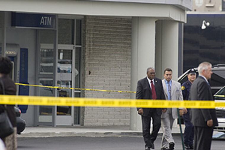 Police Commissioner Sylvester Johnson (left), flanked by chief of detectives Keith Sadler, leaves the Wachovia Bank where a fatal armored car holdup took place this morning.