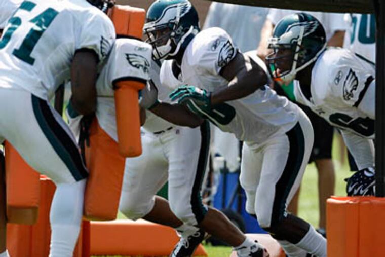 Omar Gaither, center, prepares to hit a blocker as the Eagles practice at the NovaCare Complex on Sunday. (David Maialetti / Staff Photographer)