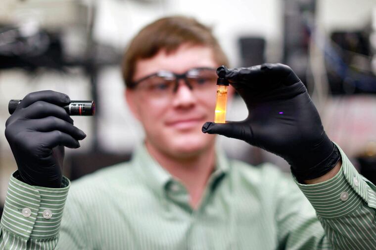 Associate professor Matt Doty holds a vial of nanoparticles he hopes to develop so when applied they improve the efficiency of solar panels.