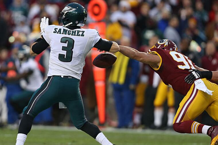 Redskins' Ryan Kerrigan strips the ball from the Eagles' Mark Sanchez during the 1st quarter. Philadelphia Eagles play the Washington Redskins at FedEx Field in Landover, MD on December 20, 2014. (David Maialetti/Staff Photographer)