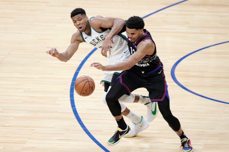The Sixers' Tobias Harris (right) and Bucks' Giannis Antetokounmpo battle for a rebound in the first quarter.