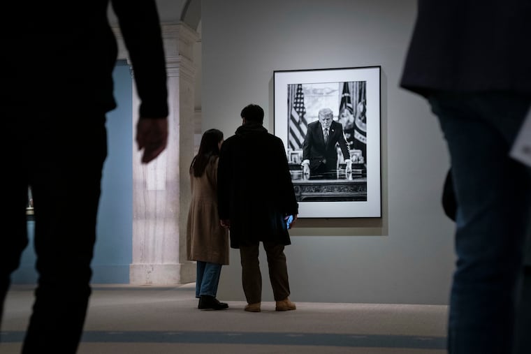 Visitors view an updated portrait of President Donald Trump, with abridged text adjoining it, on Saturday at the National Portrait Gallery in D.C.