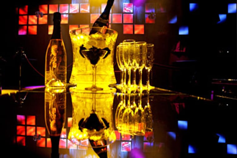 Two bottles of bubbly are atop a table at Whisper, a two-month-old nightspot on Walnut Street. (ELIZABETH ROBERTSON / Staff Photographer)