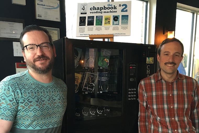 Ben Bigler (left) and Nic Esposito next to the chapbook vending machine at the Soup Kitchen Cafe in Fishtown.