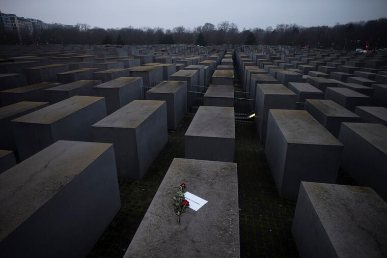 Roses with a note saying "#weremember", are placed on the Holocaust Memorial on International Holocaust Remembrance Day, in Berlin, Germany, on Wednesday.