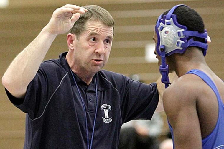 Norristown wrestling coach Mark Harner instructs Norristown wrestler Amaunte Handy. (Elizabeth Robertson/Staff Photographer)