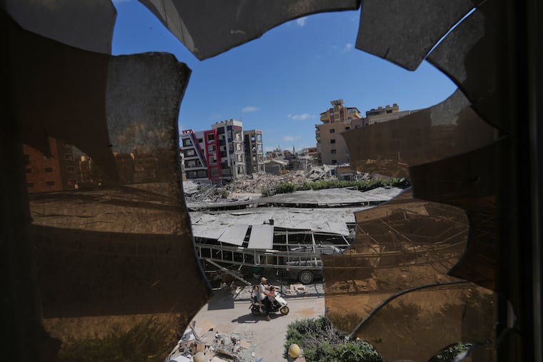 Buildings damaged by Israeli strikes are seen through shattered glass from the Jabal Amel Hospital in the southern port city of Tyre, Lebanon, Thursday, June 18, 2026.