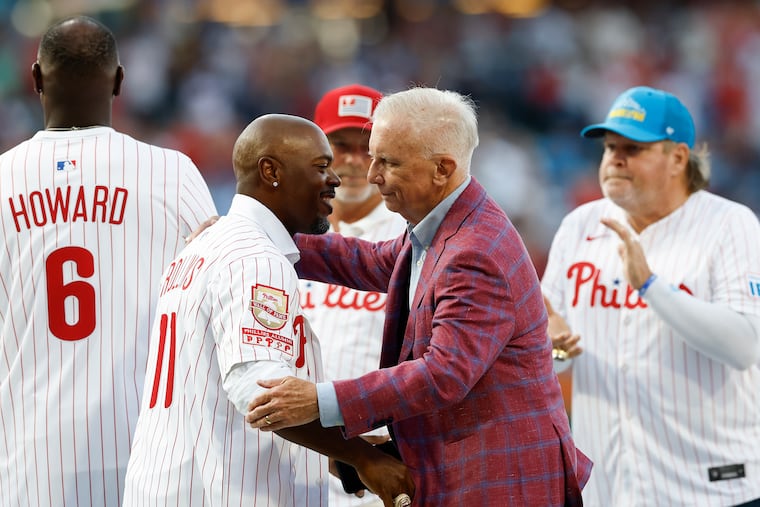 Phillies Wall of Fame recipients Jimmy Rollins and Ed Wade embrace before the Phillies played the Detroit Tigers on Friday.