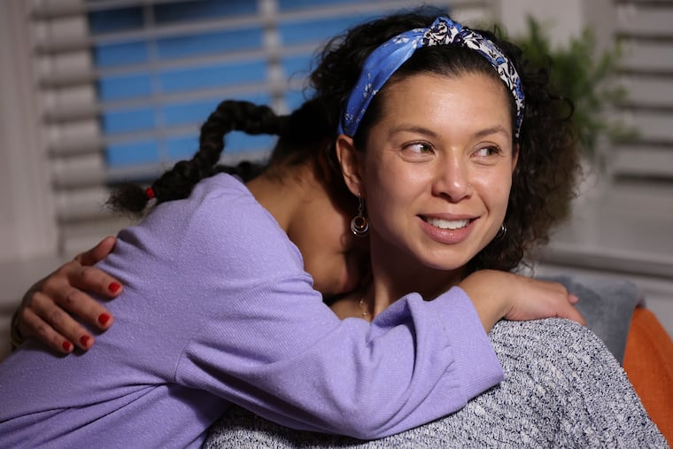 Sara Walker, 45, hugs her youngest daughter, Scarlett, 9, at their home in Jenkintown, Pa.