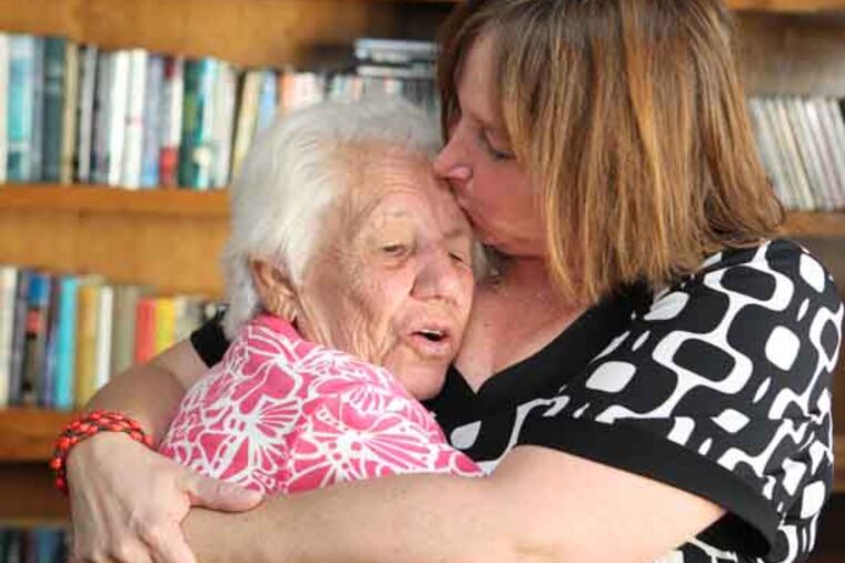 Carol Burg, right, has had her work with Alzheimer's patients at Juniper Village in Williamstown, NJ recently recognized by the Alzheimer's Association of the Delaware Valley. She gives resident Dorothy Lavin, left a hug on Sept. 17, 2013. ( CHARLES FOX / Staff Photographer )