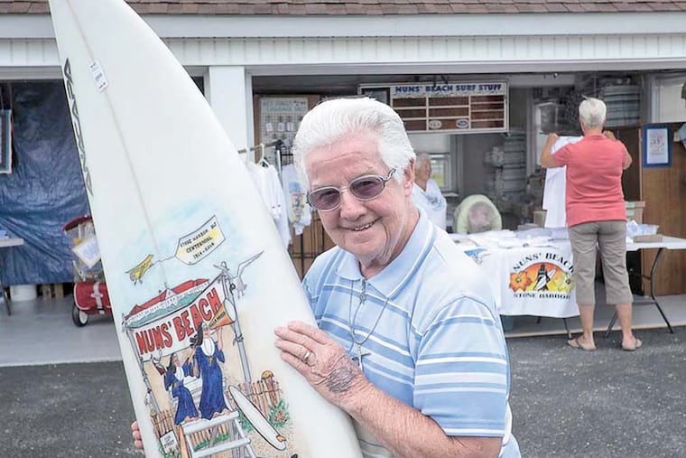 Sister James Dolores shows off a hand-painted surf board, a raffle prize for an upcoming surfing competition. The nuns operate a gift shop on their property, which also helps defray expenses. ( ED HILLE / Staff Photographer )