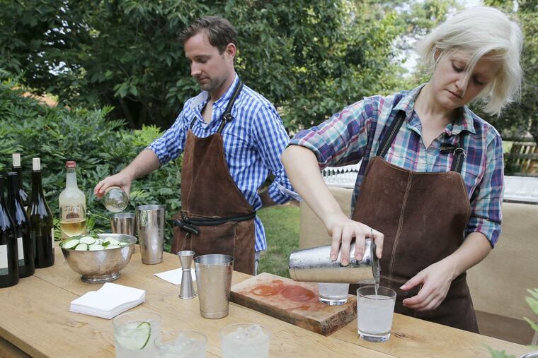 Bartenders Jon Leahy and Amy Hartranft prepare drinks at a wedding at beverage specialist Aaron Gordon's farm in Cherry Hill. Gordon provides custom cocktail services.