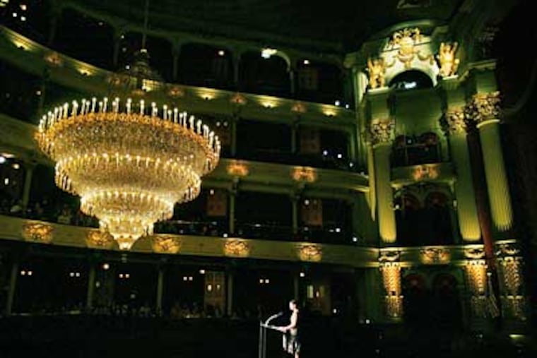 Academy of Music president Jody Lewis is dwarfed by the restored chandalier as she speaks during an unveiling ceremony there. (Eric Mencher/Inquirer)