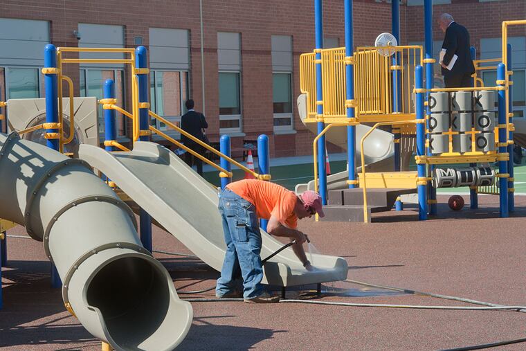 KIPP’s playground receives a last-minute sprucing-up before Wednesday’s dedication. (Avi Steinhardt/For The Inquirer)