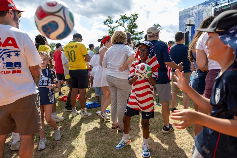 Moses Bango, 8, (center), playing with his friends Rudy Townsend, 8, (right), and Quinn Medaglia, 9, (left), at the USA vs Australia game at FIFA Fan Festival at Lemon Hill Park in Philadelphia, Pa., on Friday, June 19, 2026.