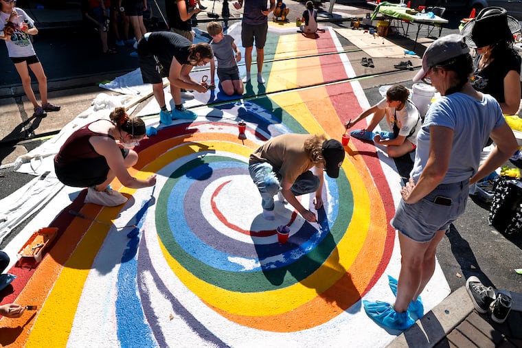 Local LGBTQ+ artist Victor Surbrook (center) joins other artists and community members painting a new public art Pride crosswalk on State Street in downtown Media on Sunday, Sept. 28. The work was sponsored by the Media Arts Council, the Media Business Authority, and the Borough of Media and was completed in one day.