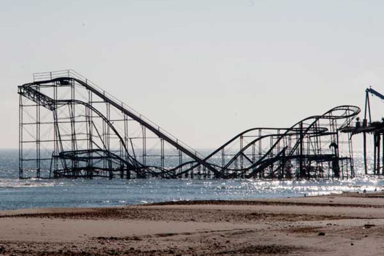 The Jersey shore two weeks after Hurricane Sandy on Nov. 12, 2012. Here, in Seaside Heights, a sailboat glides by a roller coaster in the ocean. APRIL SAUL / Staff Photographer