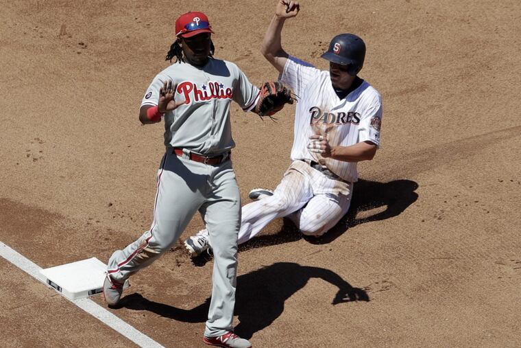 The Padres’ Wil Myers steals third base Wednesday as third baseman Maikel Franco motions. Myers stole three bases in a row.