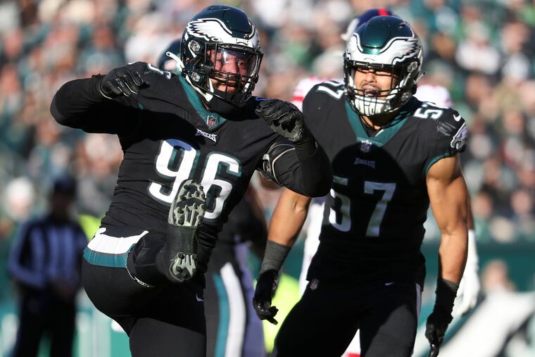 Eagles defensive end Derek Barnett kicks his leg after stoping New York Giants running back Saquon Barkley with teammate middle linebacker T.J. Edwards in the second quarter on Sunday, December 26, 2021 in Philadelphia.