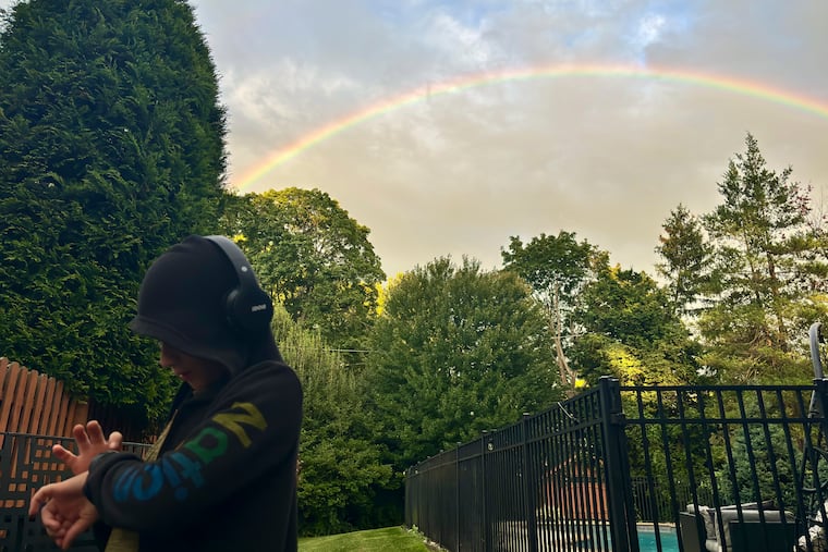 Adam Shefer, 9, looks at this watch standing in his Merion neighborhood as a rainbow fills the sky after rain fall on Sept. 7. The 0.35 inches that fell that day made it the rainiest day of a very dry month.