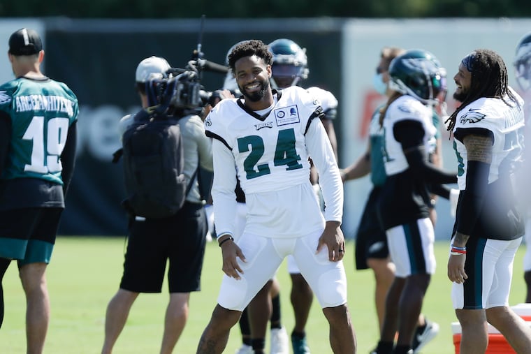 Eagles cornerbacks Darius Slay (center) and Avonte Maddox laugh during training camp Monday.