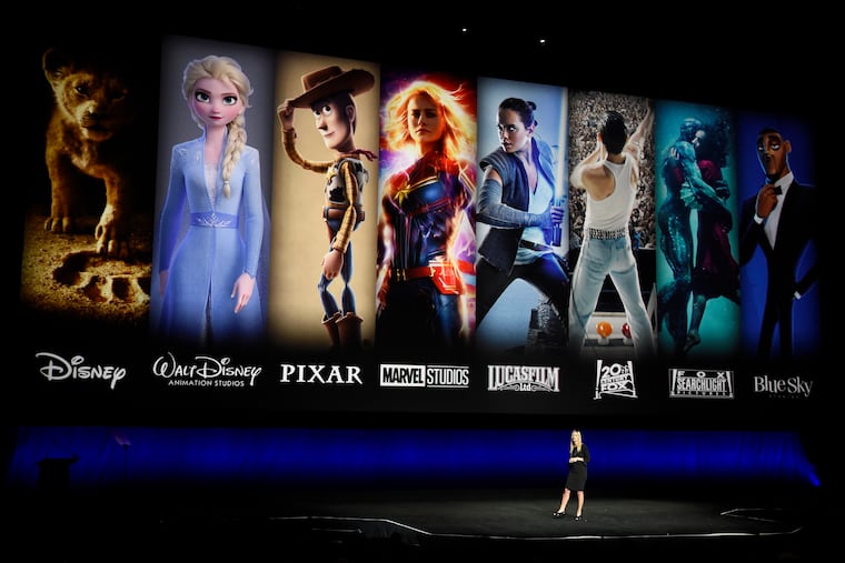 FILE - In this April 3, 2019, file photo characters from Disney and Fox movies are displayed behind Cathleen Taff, president of distribution, franchise management, business and audience insight for Walt Disney Studios during the Walt Disney Studios Motion Pictures presentation at CinemaCon 2019, the official convention of the National Association of Theatre Owners (NATO) at Caesars Palace in Las Vegas. On Tuesday, Nov. 12, Disney Plus launches its streaming service. (Photo by Chris Pizzello/Invision/AP, File)