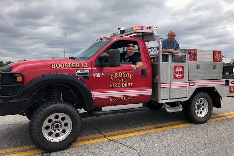 A Crosby, Texas, volunteer fireman with an evacuee answers questions on road closures from bystanders near a chemical plant authorities said was going to explode.