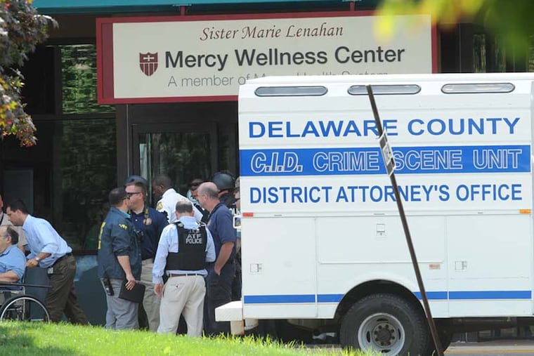 A patient leaves the Mercy wellness center after a shooting incident that left a woman dead and two men wounded. ( CLEM MURRAY / Staff Photographer )