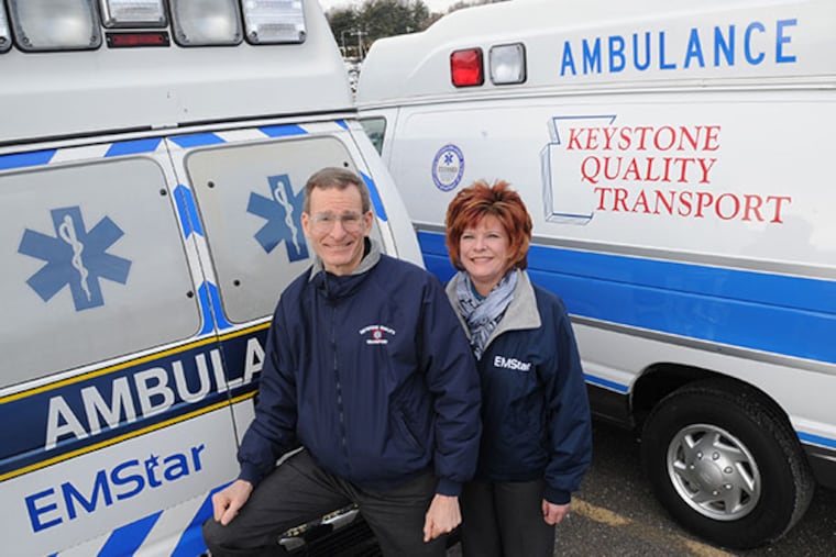 Steve Barr, left, President and CEO of Keystone Quality Transport, and Suzannae Shubert, the Customer Care Manager, stand between two ambulances Feb. 27, 2014. ( CLEM MURRAY / Staff Photographer )