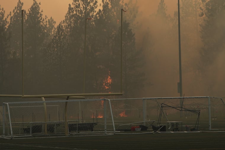 Old Trails Fire burns near Dwight Merkel Sports Complex, Saturday, Aug. 1, 2026, in Spokane, Wash. Thousands of people were evacuated.