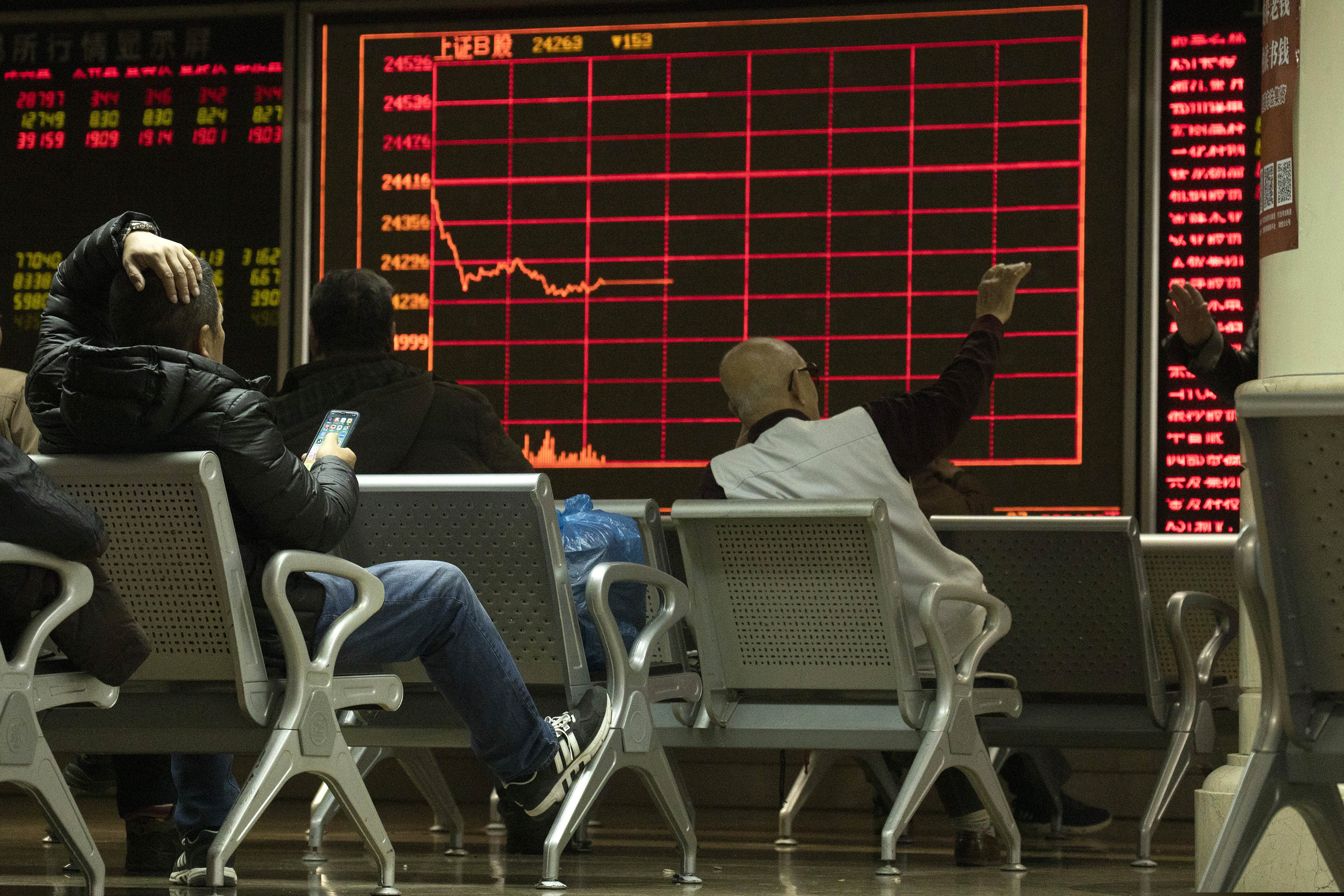 In this Thursday, Dec. 12, 2019, photo, investors monitor stock prices at a brokerage in Beijing. Shares likewise jumped Friday, Dec. 13, 2019 in Asia following fresh all-time highs overnight on Wall Street.