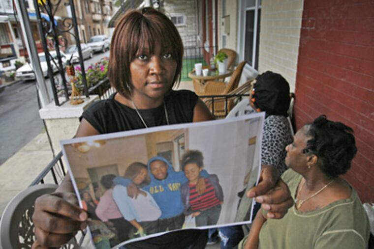 Felicia Travis holds a family photo of her nephew Troy Travis, who was shot and killed yesterday. (Alejandro A. Alvarez / Staff Photographer)