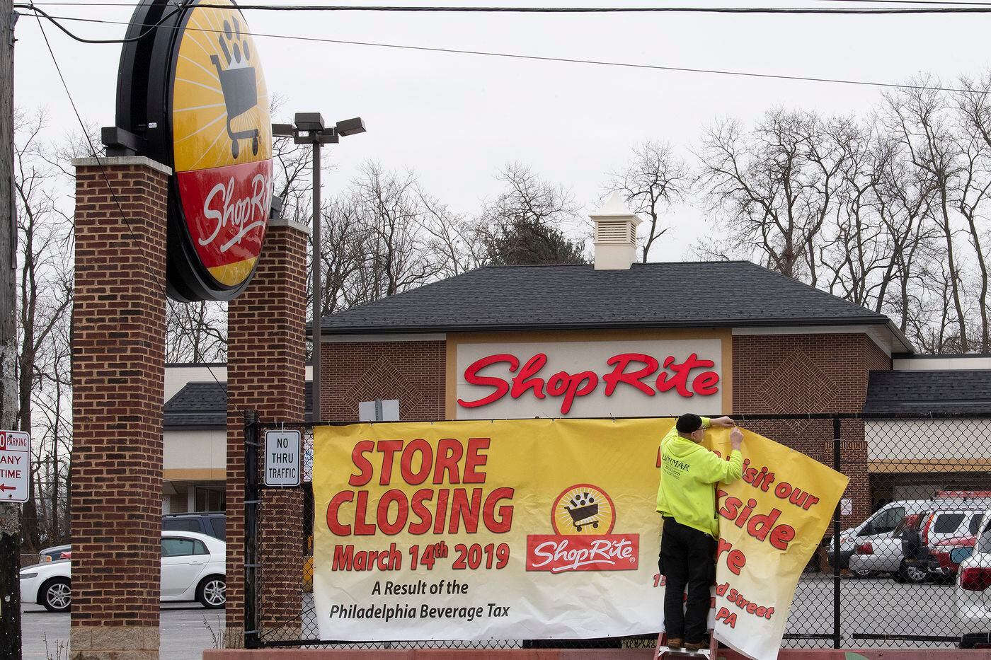 A worker hangs a store closing sign at the ShopRite at 67th and Haverford in West Philadelphia in January 2019.