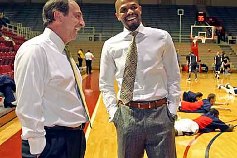 Fran Dunphy, left, chats with one of his former players and Penn's interim coach Jerome Allen. (Steven M. Falk / Staff Photographer)
