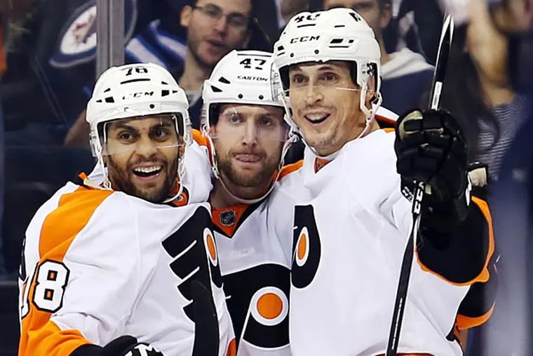 Philadelphia Flyers forward Vincent Lecavalier (40) celebrates his goal with Philadelphia Flyers forward Pierre-Edouard Bellemare (78) and defenceman Andrew MacDonald (47) during the third period against the Winnipeg Jets at MTS Centre. Philadelphia wins 4-3 in overtime. (Bruce Fedyck/USA Today)
